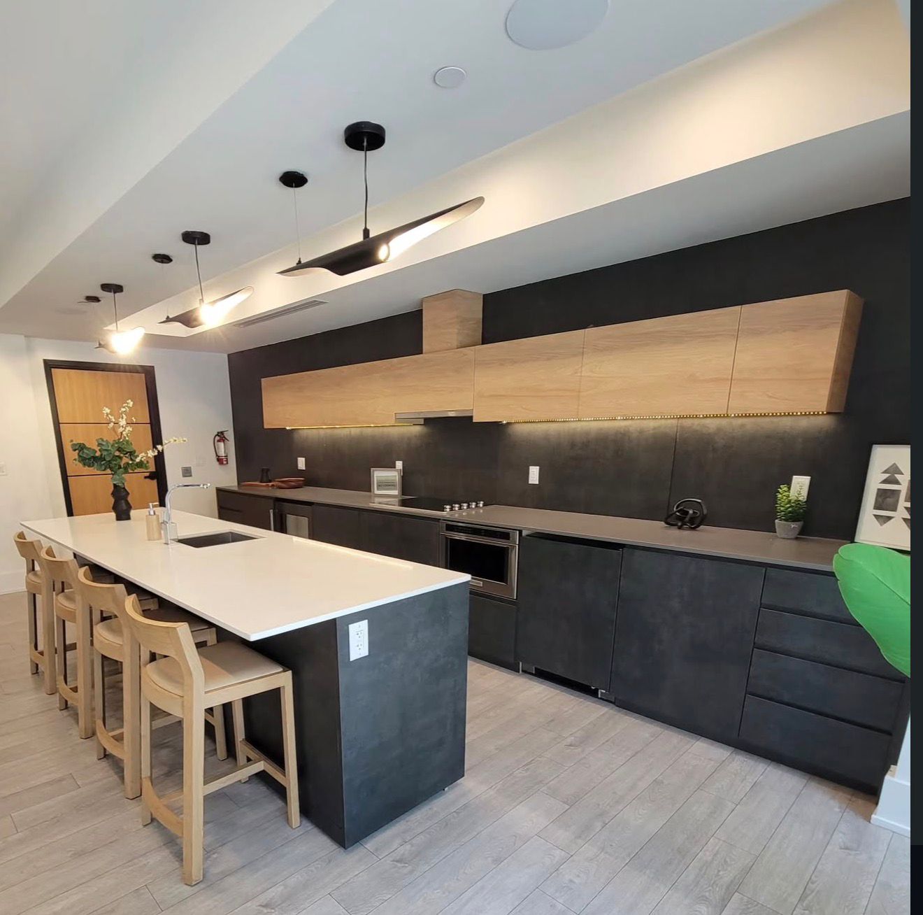 Commercial kitchen and lounge build-out with matte black cabinetry and quartz island, 1055 West Georgia Street, Vancouver