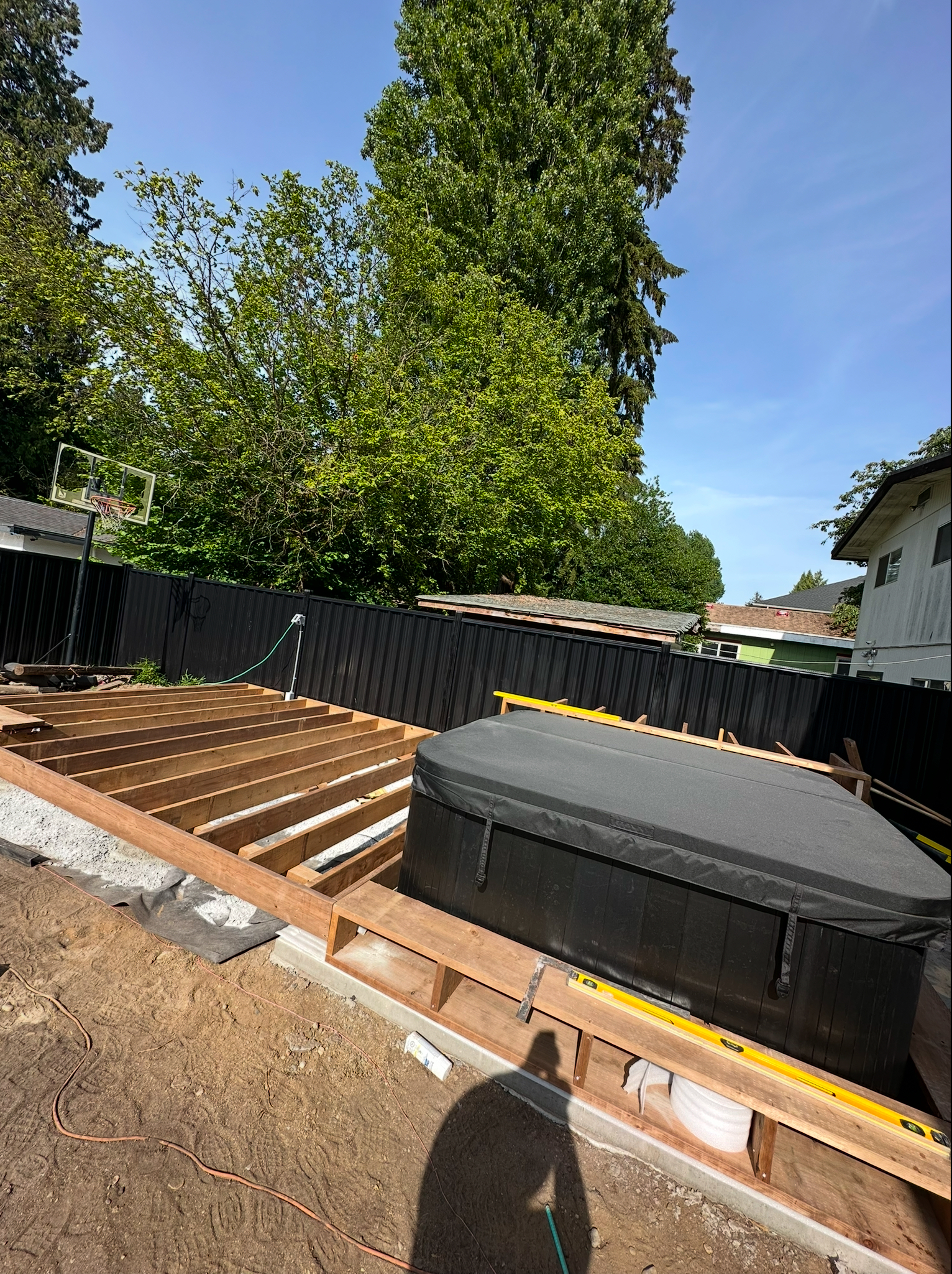 Pressure-treated deck framing and hot tub base during a backyard renovation