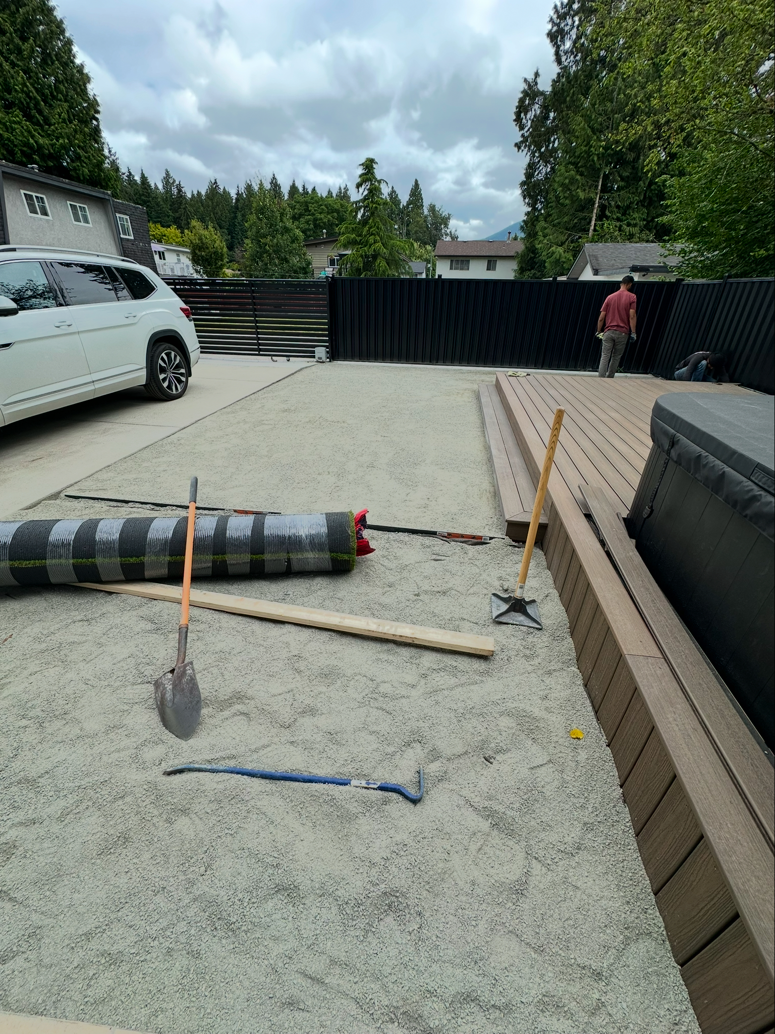 Backyard landscaping in progress with compacted gravel base for artificial turf beside a new composite deck, Port Coquitlam