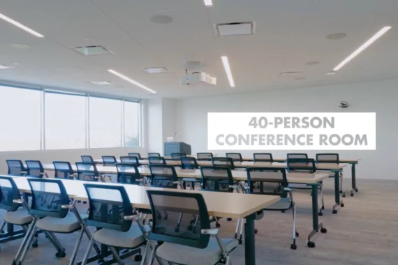 Conference room fitted with rows of desks and chairs, labelled 40 person conference room
