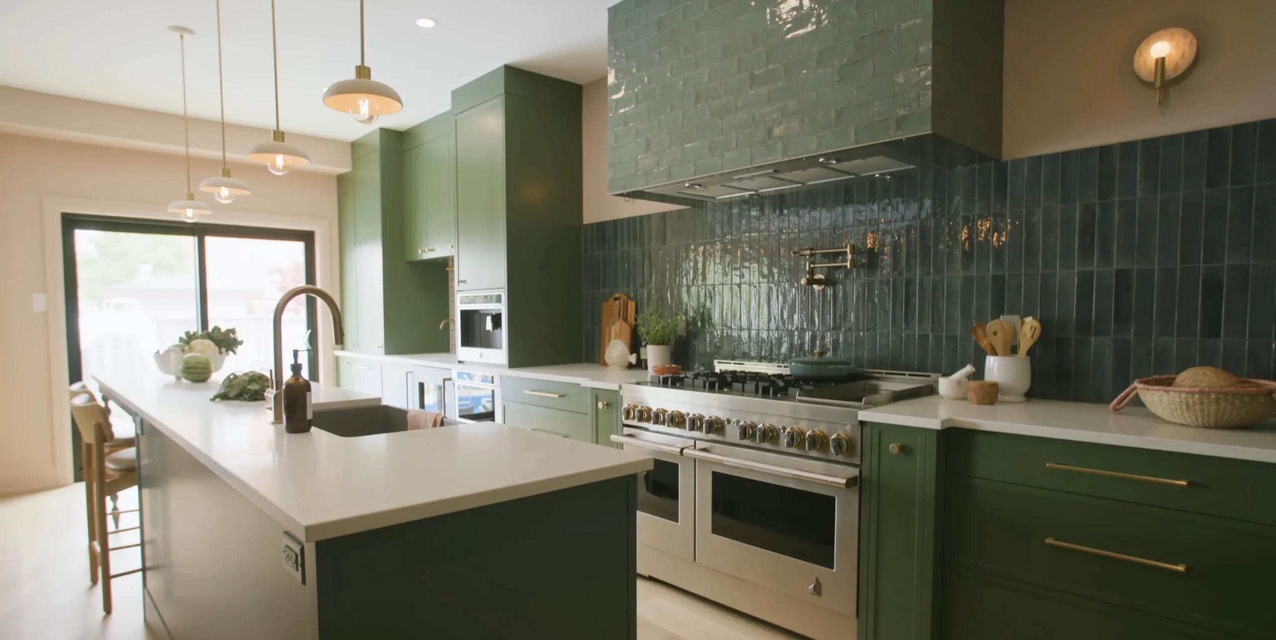 Finished kitchen renovation with sage green cabinetry, glazed tile backsplash and quartz countertops