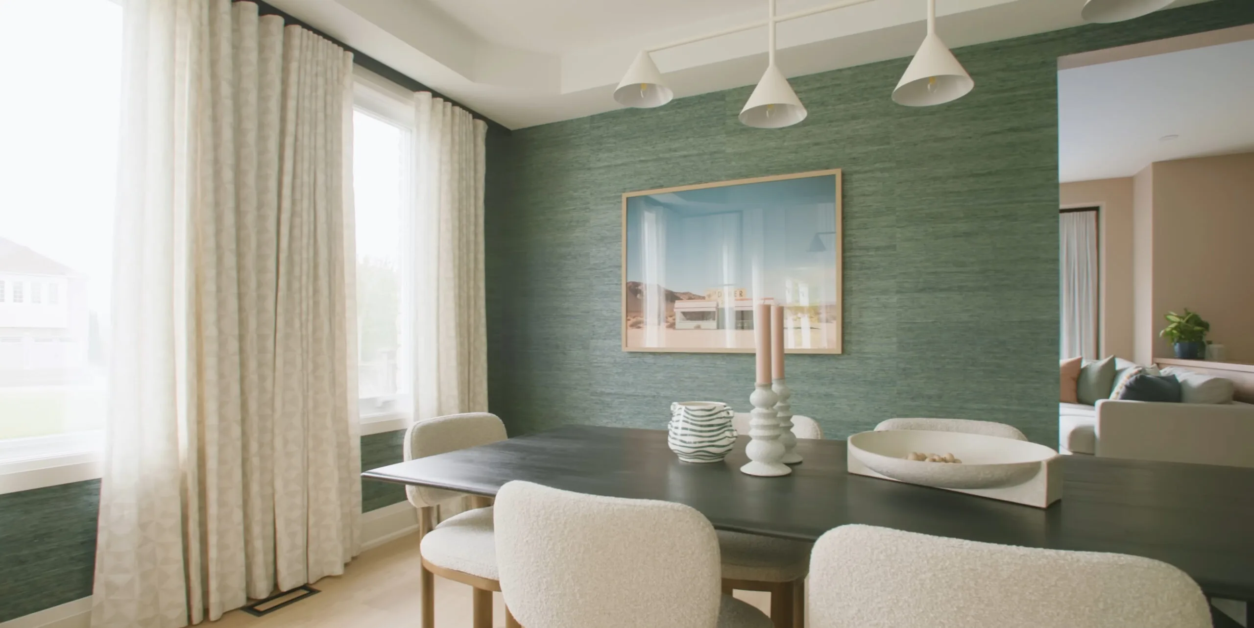 Dining room with a dark wood table, upholstered chairs and a green textured feature wall