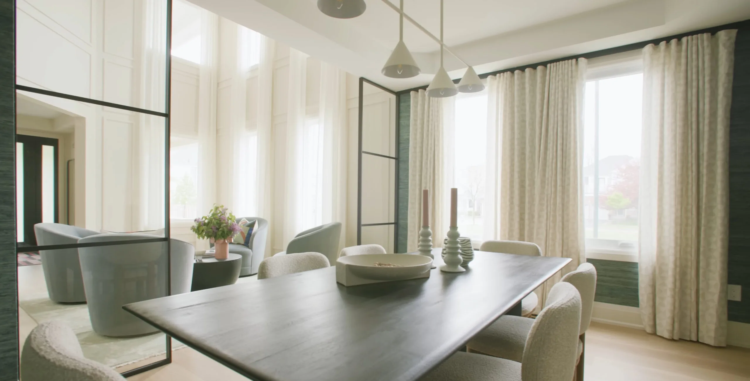Dining room with a dark wood table, pendant lights and sheer curtains